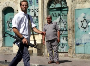 A Jewish settler walks past a Palestinian on Shuhada Street  in the West Bank city of Hebron. Nayef Hashlamoun Reuters