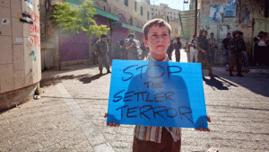 Palestinian boy holds sign in Hebron  Source Shutterstock  Mother Jones
