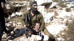An Israeli soldier puts a Palestinian boy in choke hold for allegedly throwing rocks at Israeli tanks. Source Ha'aretz.