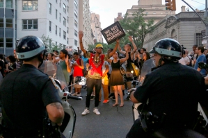 Protesters, marching against the killing of Alton Sterling and Philando Castile, hold placards towards members of the New York Police Department on motorbikes in Manhattan, New York, U.S., July 7, 2016. Picture taken July 7, 2016. REUTERS/Bria Webb - RTX2KE8I